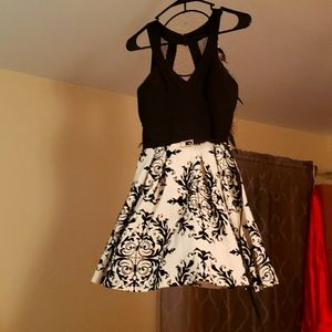 A mini dress with a black top and white shirt with design attached with tulle